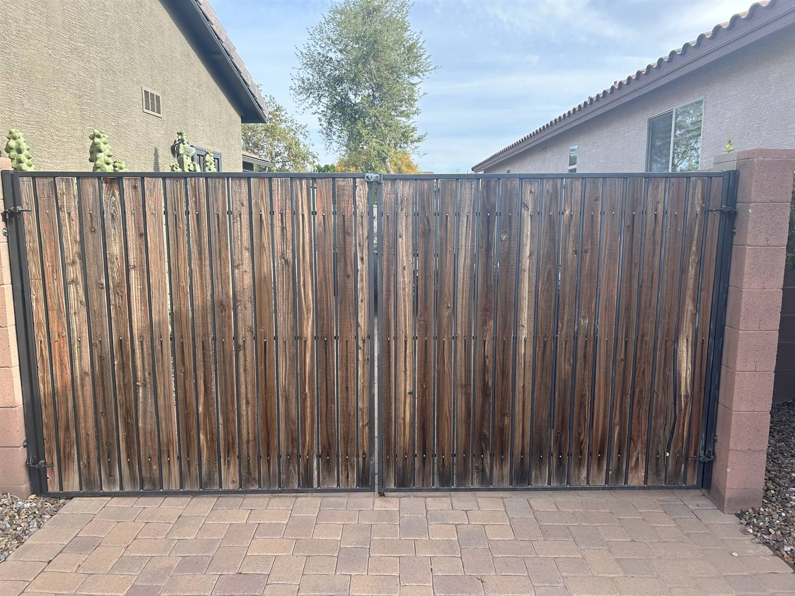 Large double driveway gate with faded, weathered wood slats before refurbishment