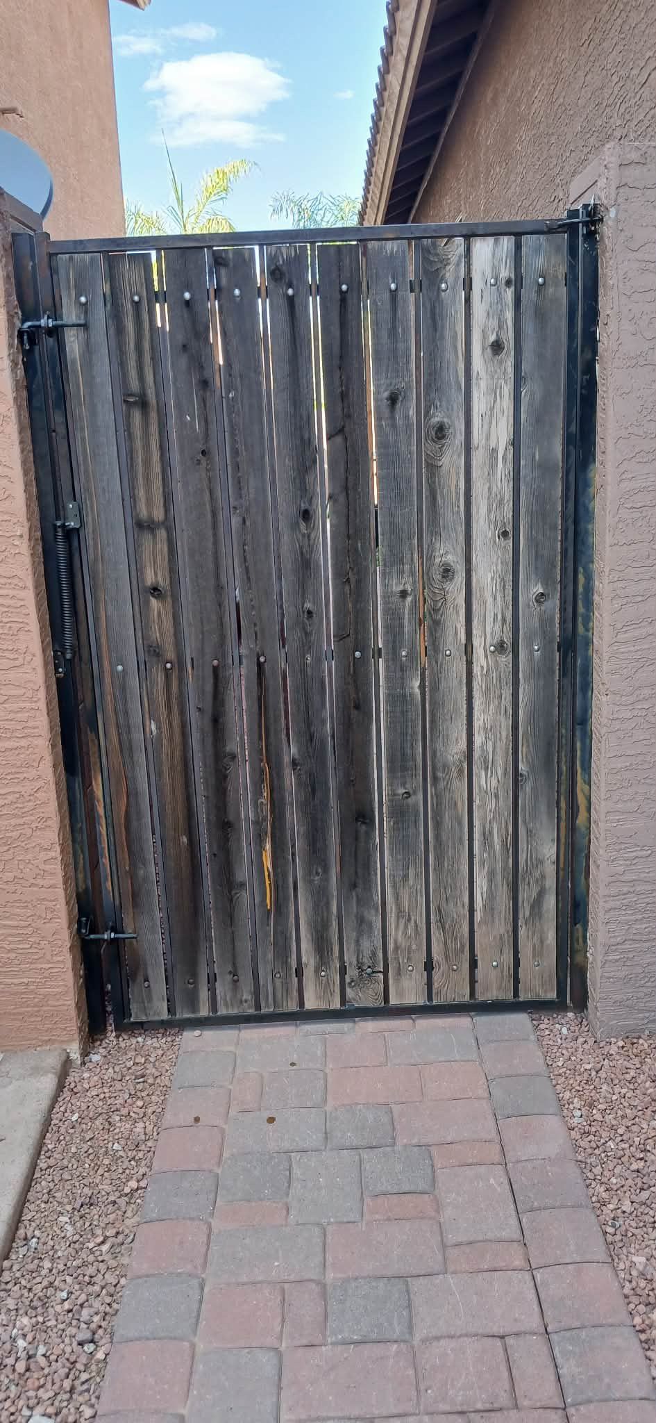 Old gate with weathered, greying wood slats before refurbishment